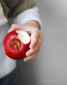 eien Hand hält einen angebissenen Apfel 